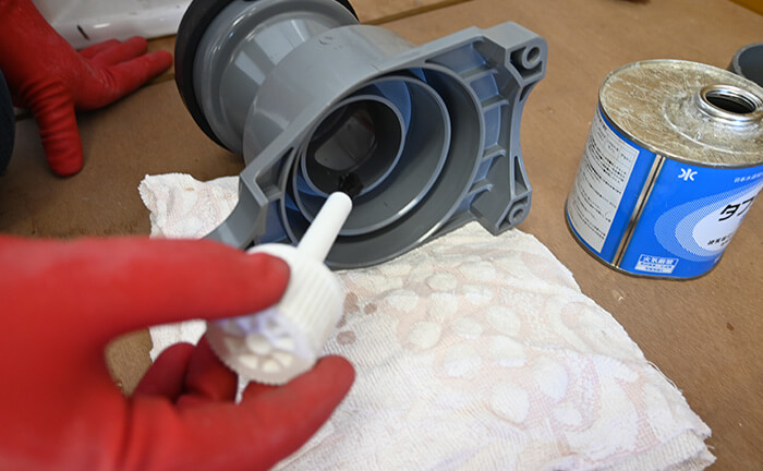 排水ソケットに接着剤を塗る
